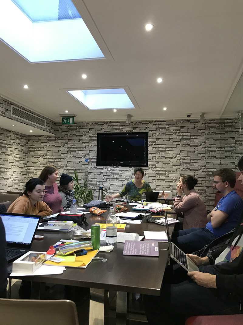 A wide shot of students seated at a rectangular table on the London 2020 Study Abroad trip.